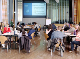Photograph of learners at tables viewing the training on a screen.